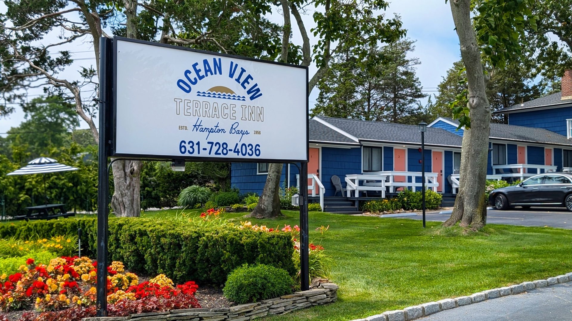 Ocean View Terrace Inn dark marine blue exterior with charming pink doors in Hampton Bays, NY